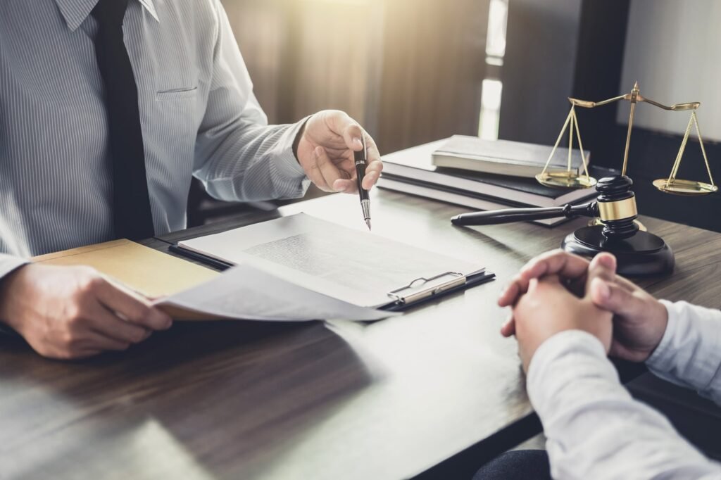 An attorney pointing to legal documents during a client consultation at a desk with a gavel and scales of justice, representing Personal Injury Doral Florida legal services.