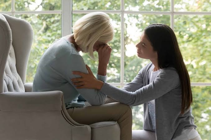 A young woman comforting a grieving relative in an armchair, representing Wrongful Death Miami Florida legal services.