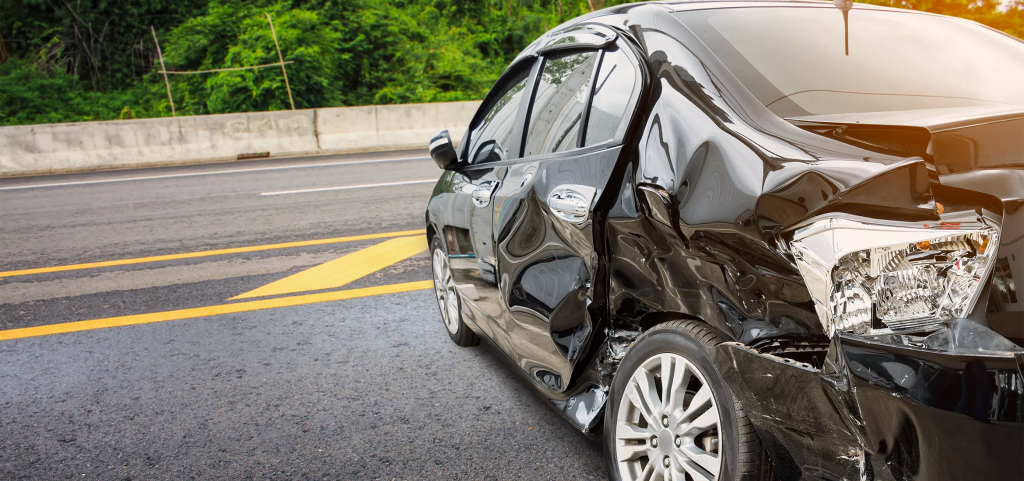 Detailed close-up of severe rear passenger-side damage to a black sedan after a collision, highlighting crushed metal and a broken tail light assembly. Extensive damage like this often requires the expertise of a Car Accident Claim Attorney for insurance purposes