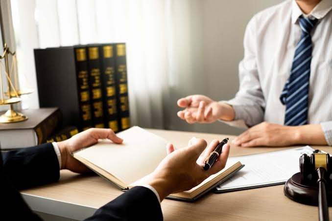 Serious Injury Attorney discussing case details across a desk with law books, documents, and a gavel.