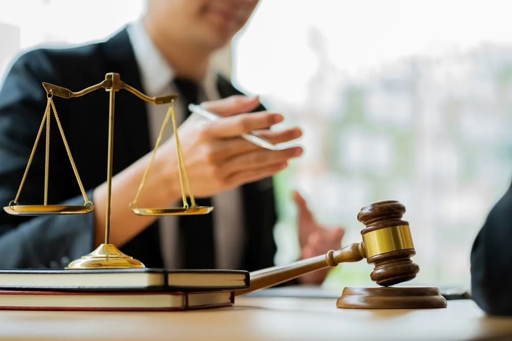 Serious Injury Attorney explaining legal rights during a consultation with scales of justice and a gavel on the desk.