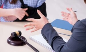 An injured client wearing an arm sling sits across a table discussing a claim with a legal professional beside a wooden gavel, demonstrating an initial consultation with an experienced Personal Injury Case Lawyer.